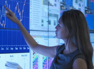 Woman pointing to graph on a large screen